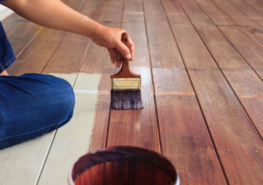 person-painting-wooden-deck