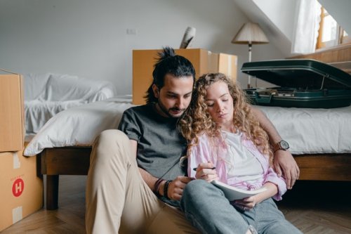 couple sitting on the floor discussing property management.