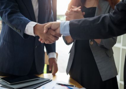 A Vienna landlord and property manager shake hands, both in suits.